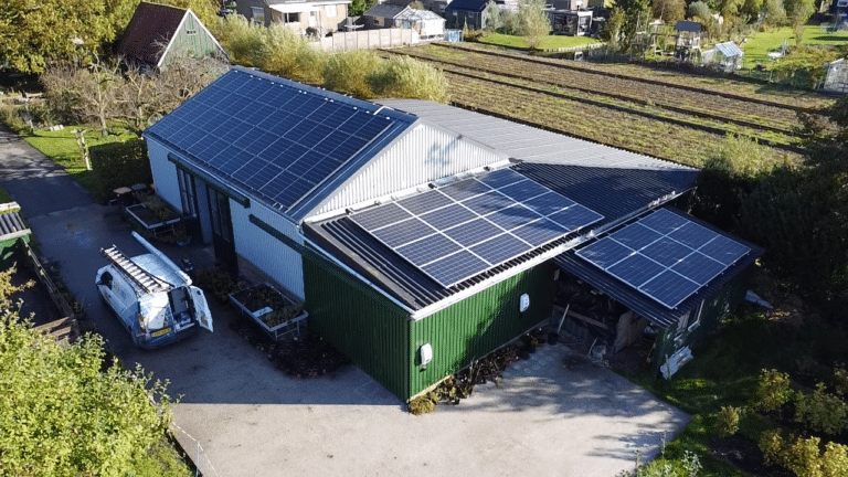 Luchtfoto van EVLAC in Venhuizen. Op het dak zijn zonnepanelen te zien. Naast de schuur staat een bus van Zonzo. Met de werkzaamheden binnen zorgt dit voor een compleet duurzame installatie