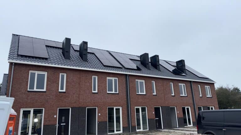 Afbeelding van een woningcomplex dat helemaal nieuw is gebouwd. Op het dak zijn zonnepanelen geplaatst die de woningen voorzien van een duurzaam energiegebruik.